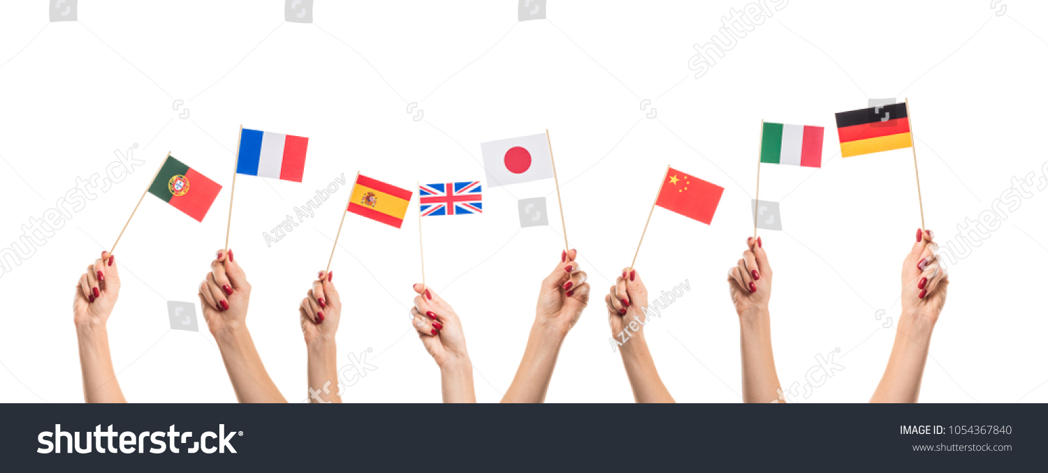 National flags of Germany, England, Italia, Japan, China Spain, France, Portugal in hands. Language studying concept on white background #1054367840