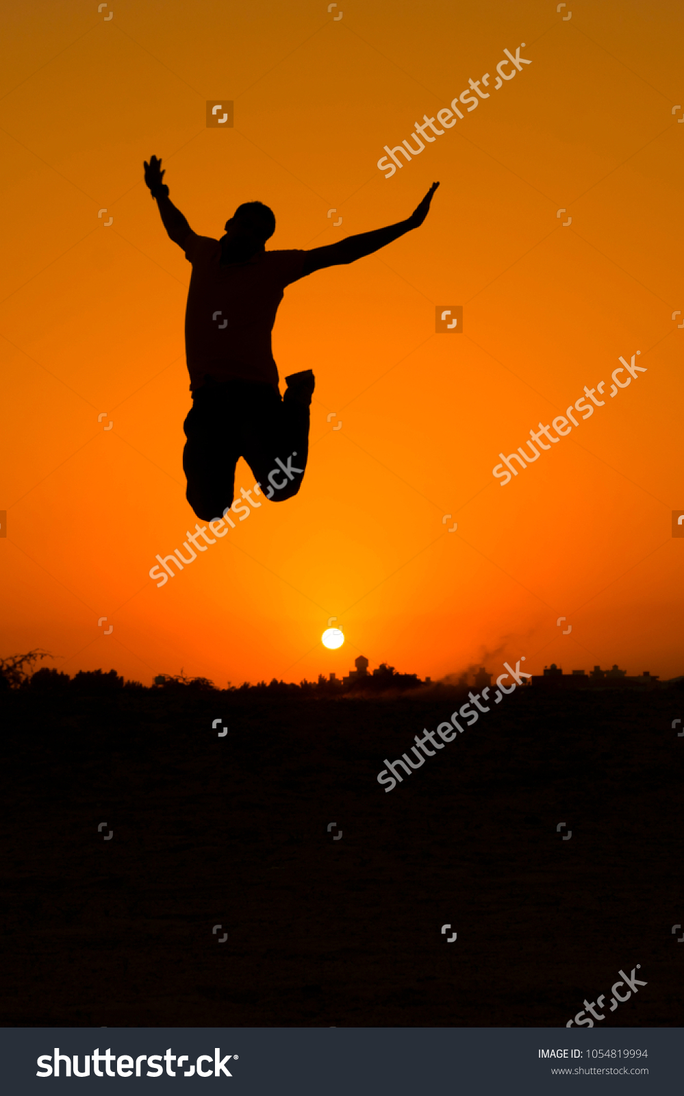 The silhouette of people jumping with sunset background,concept of happiness, joy, joyful life #1054819994