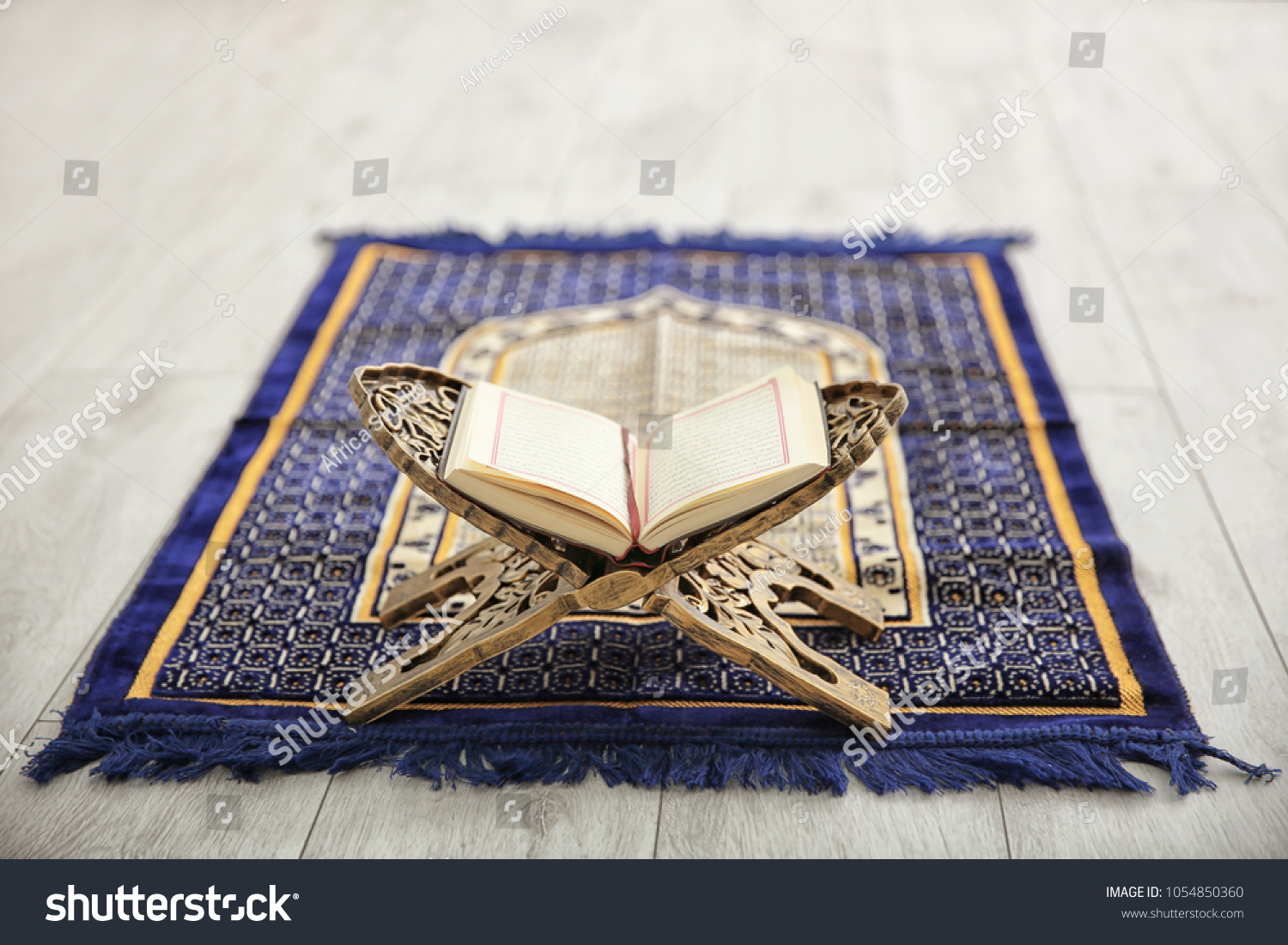 Opened Quran on Muslim prayer mat indoors #1054850360