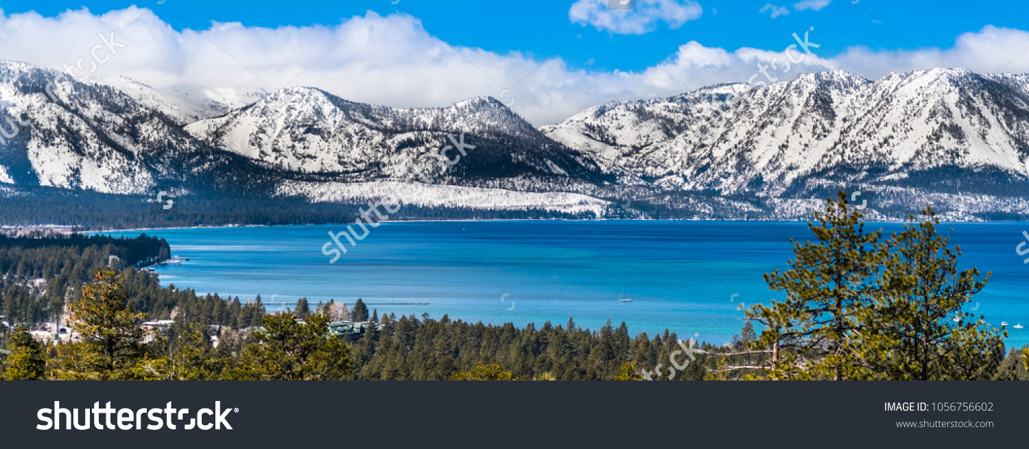 Panoramic view towards Lake Tahoe on a sunny clear day; the snow covered Sierra mountains in the background; evergreen forests in the foreground #1056756602