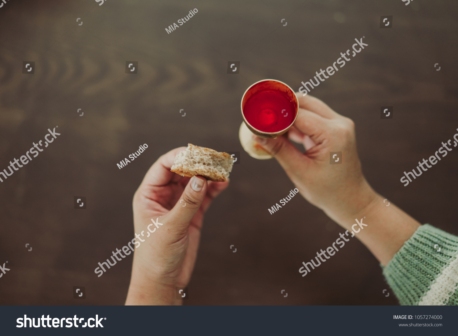 Holy communion in church.Taking holy Communion.Cup of glass with red wine, bread.The Feast of Corpus Christi Concept. #1057274000