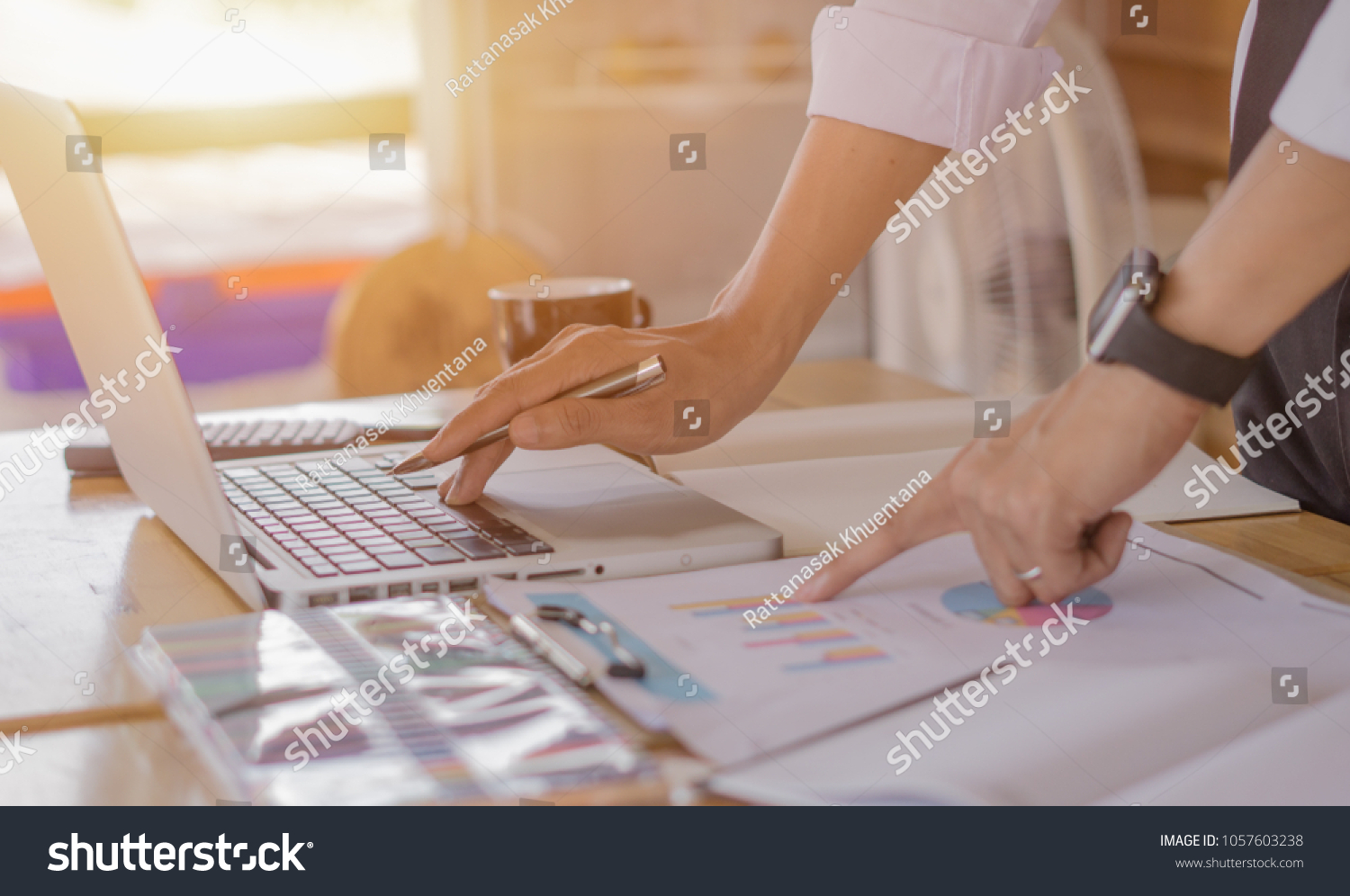 Business man working at office with laptop, tablet and graph data documents on his desk. #1057603238