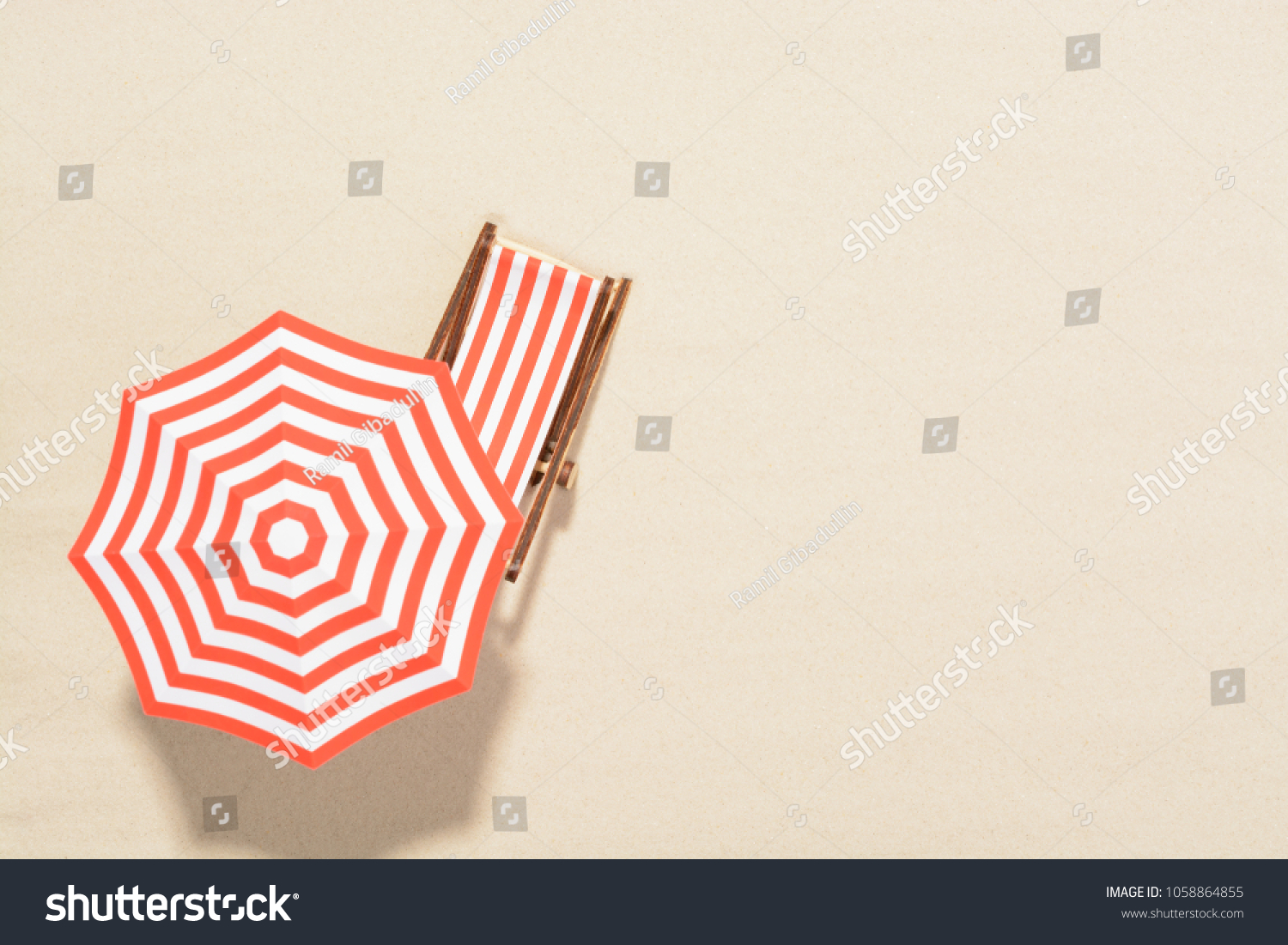 The concept of summer vacation. Top view on a sun lounger under an umbrella on the sandy beach #1058864855