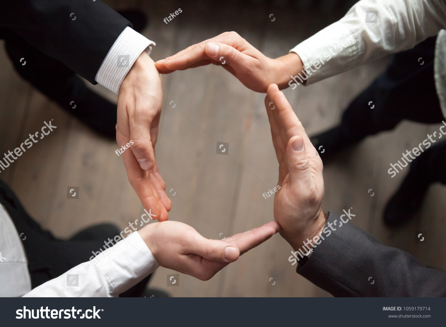 Business team people join hands forming circle, business protection, unity in care and support, shared corporate responsibility, help in teamwork, synergy trust safety concept, close up top view #1059179714
