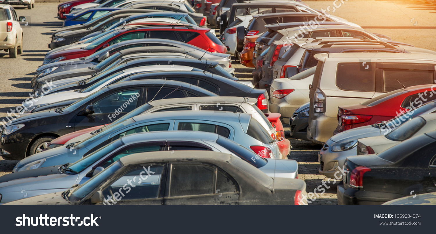 parked used cars stand on street during the day #1059234074