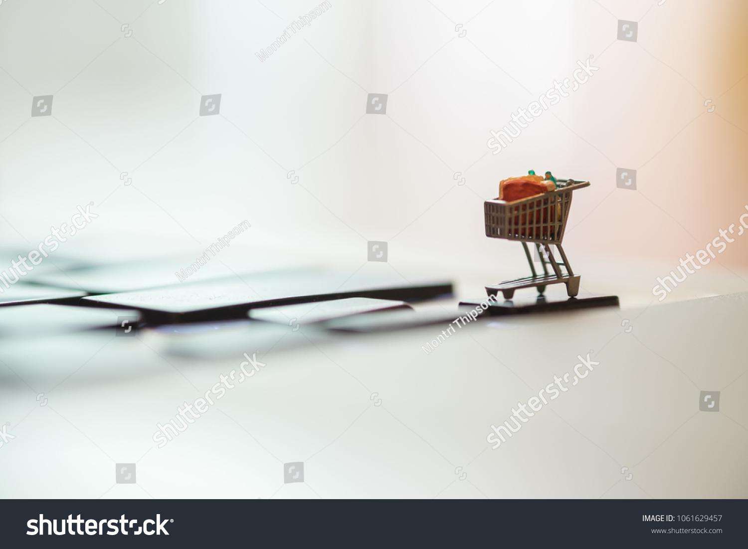 Close up of shopping cart or trolley miniature figure toy on laptop computer. Shopping, retail and e-commerce concept. #1061629457