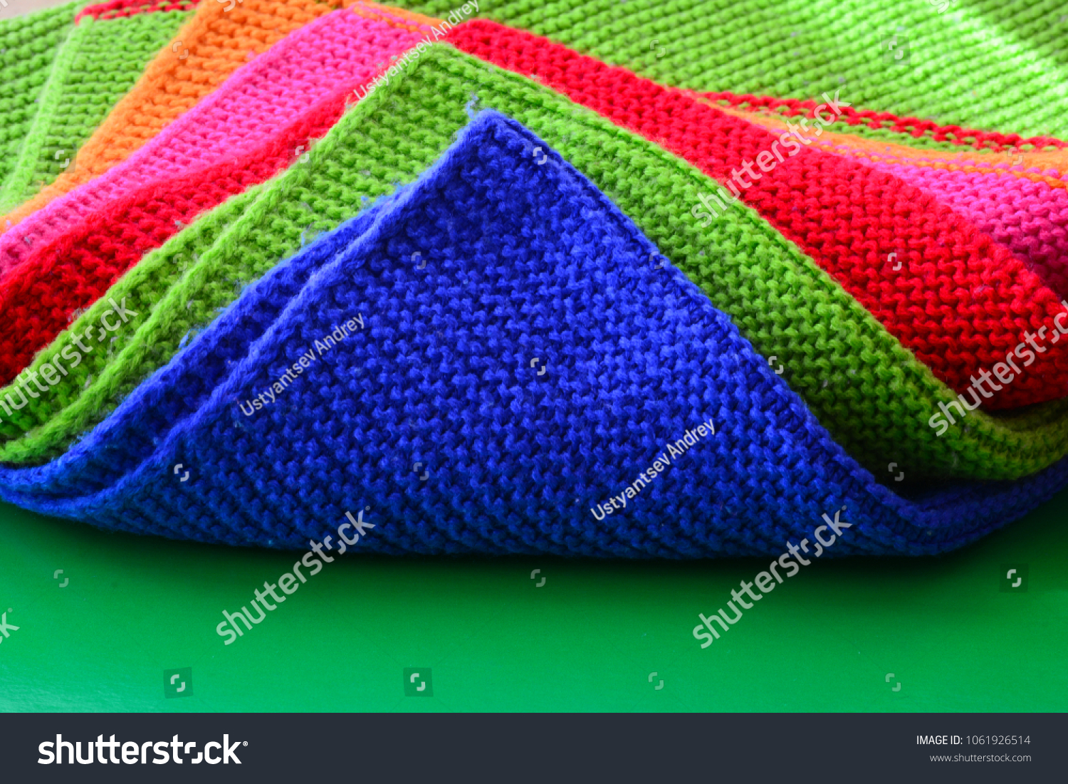 Colorful wool cloth on a green background. Textile pattern, wool cloth.  #1061926514