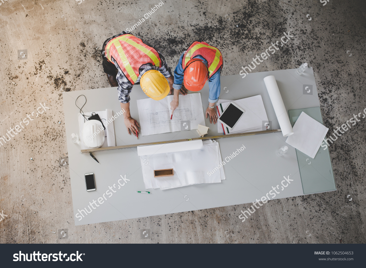 Top view of architects and engineers to help create a blueprint to build a modern building equipped with the skills to fix errors and make suggestions during construction. #1062504653