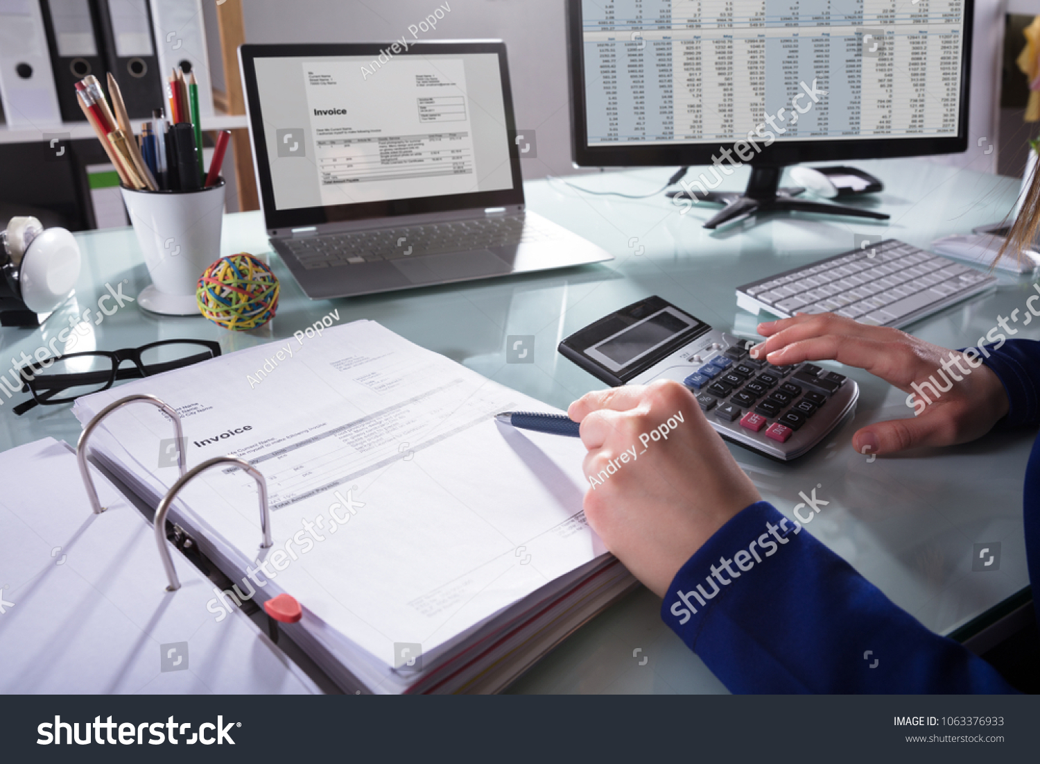 Close-up Of A Businessperson's Hand Calculating Invoice At Workplace #1063376933