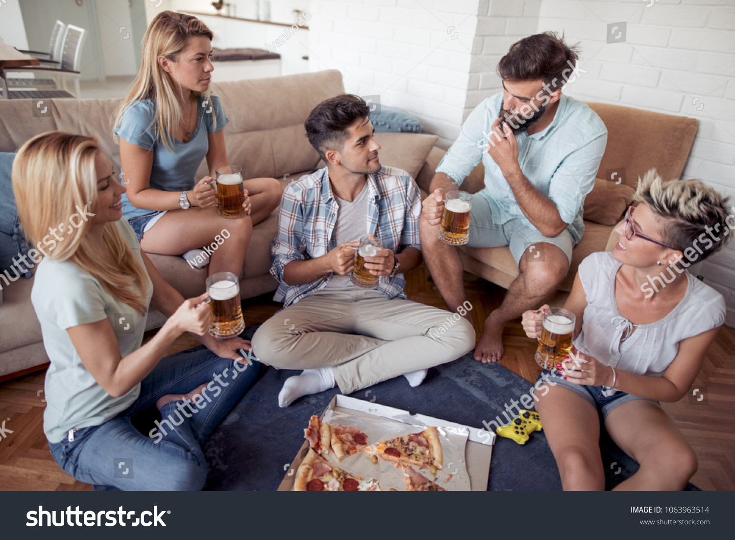 Group of playful young people eating pizza while having fun together. #1063963514
