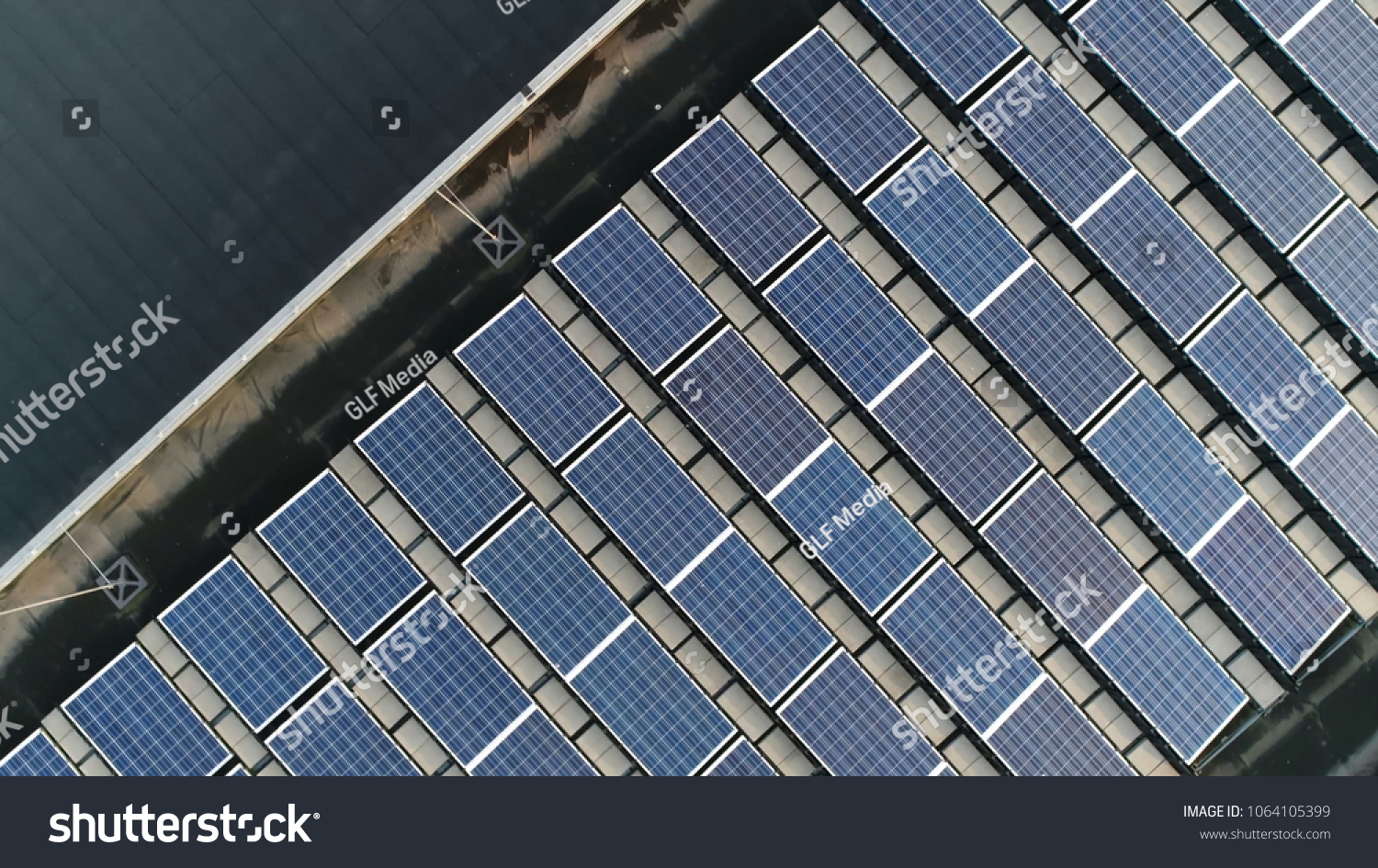 Aerial top down photo of solar panels PV modules mounted on flat roof photovoltaic solar panels absorb sunlight as a source of energy to generate electricity creating sustainable energy #1064105399