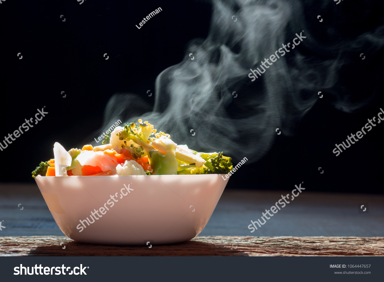The steaming hot  from Mixed vegetables on white bowl dark background selective focus. #1064447657
