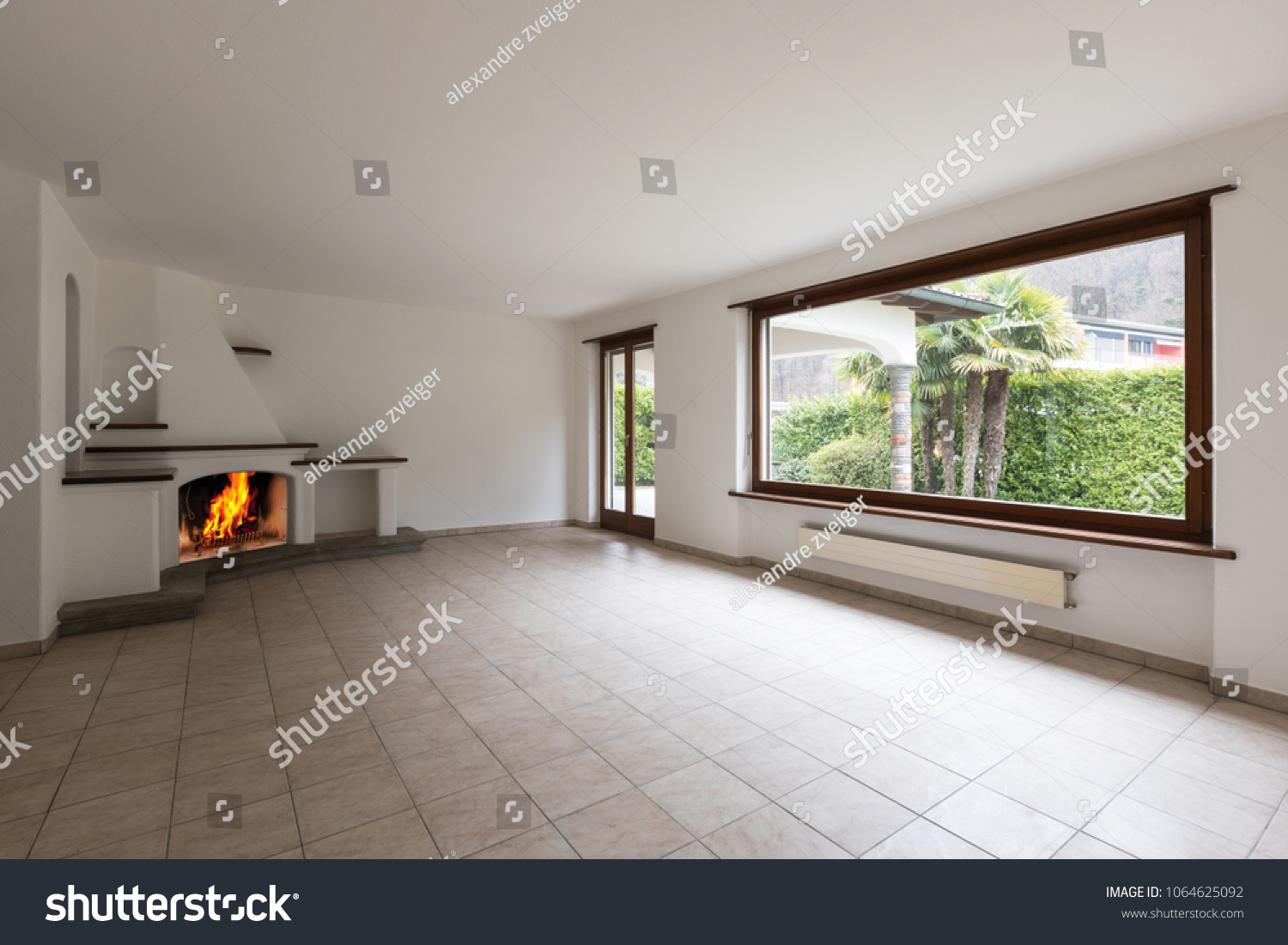 Room with large windows and lit fireplace on a cold winter day. Nobody inside #1064625092