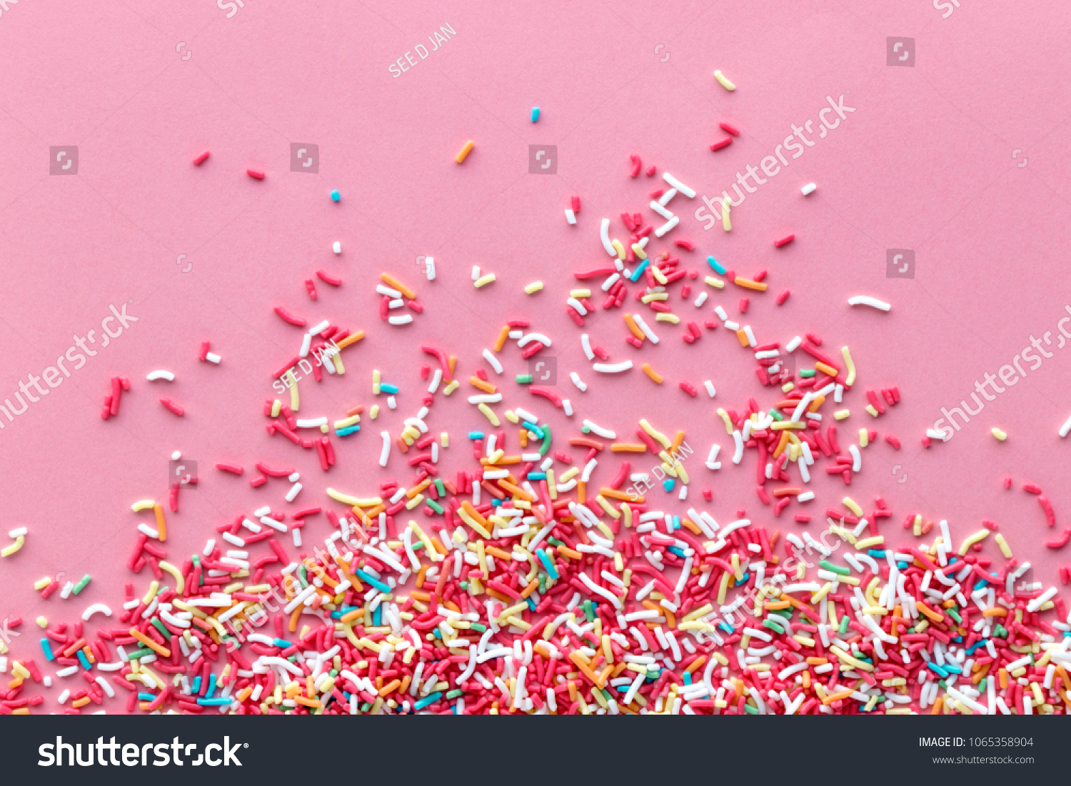 Colorful sprinkles on a pink background, top view with copy space #1065358904