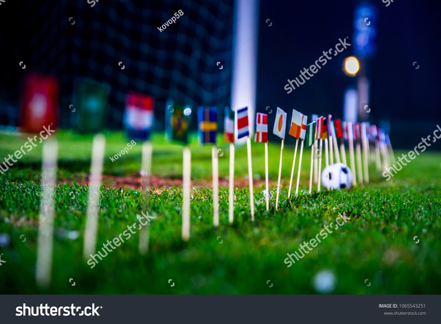 Football ball on green grass and all national flags  #1065543251