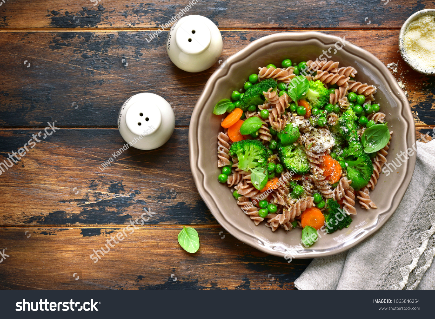 Whole wheat pasta primavera in a rustic bowl on an old wooden background.Top view with copy space. #1065846254