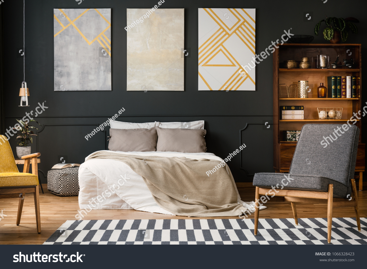 Modern bedroom interior with big bed, grey and white carpet, chairs, paintings, lamp and bookcase with books and decorations #1066328423