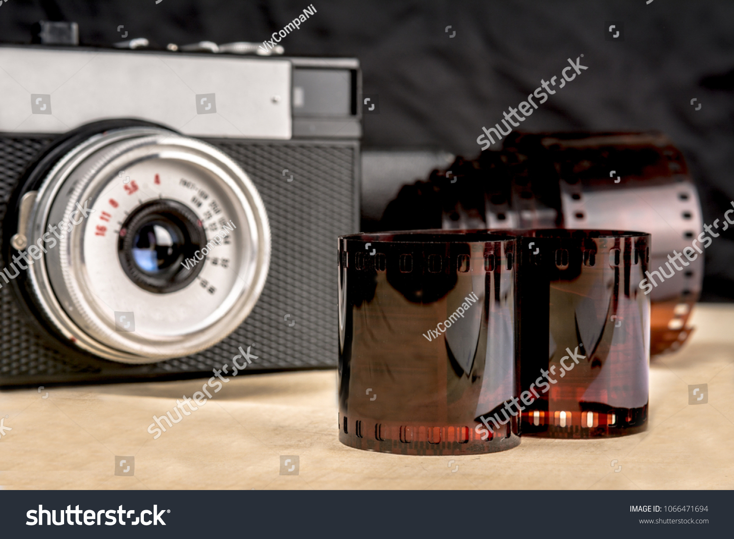 Wooden table on it a camera and a film for him #1066471694