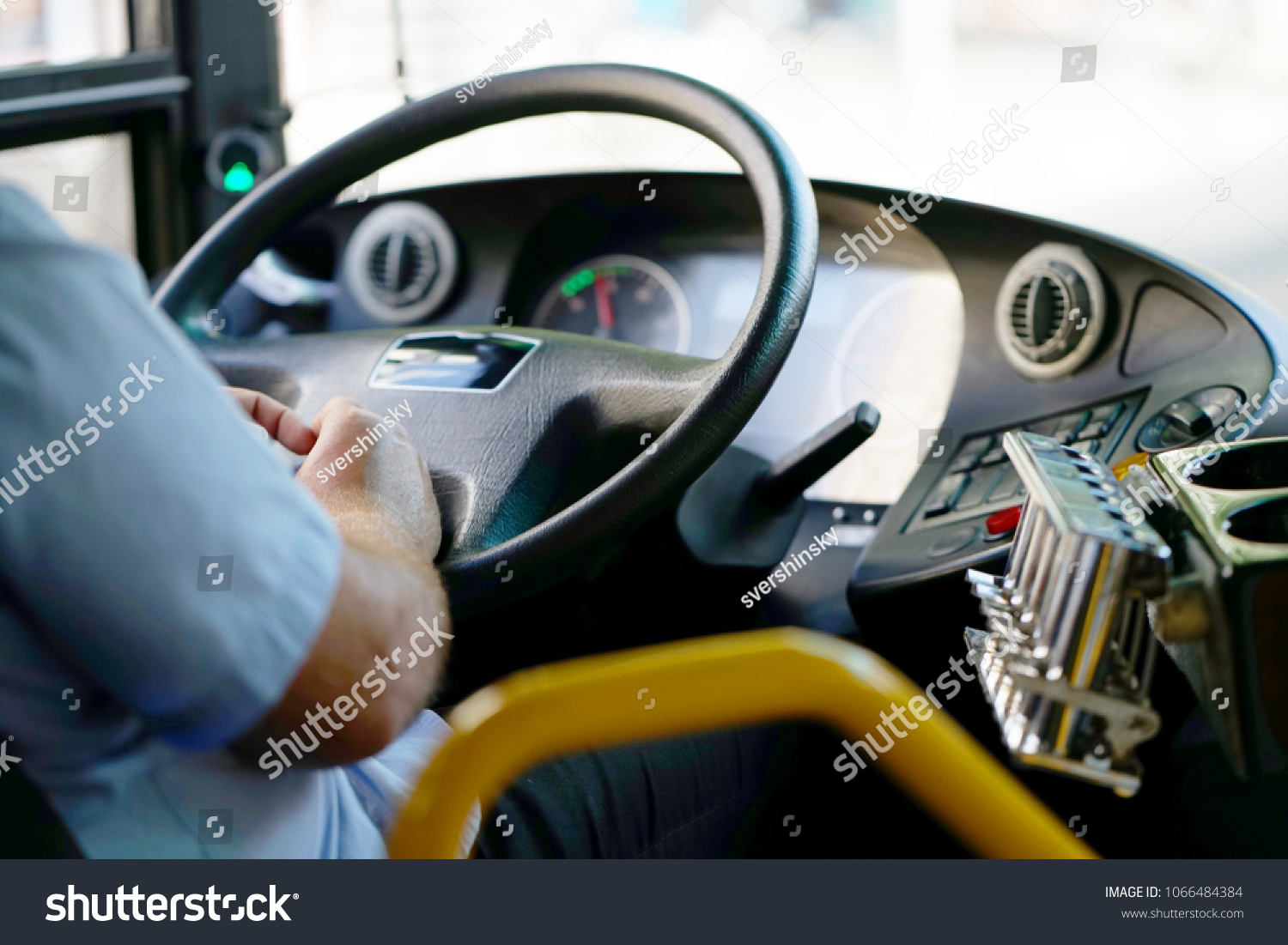 Hands of driver in a modern bus by driving.Concept - close-up of bus driver steering wheel and driving passenger bus #1066484384