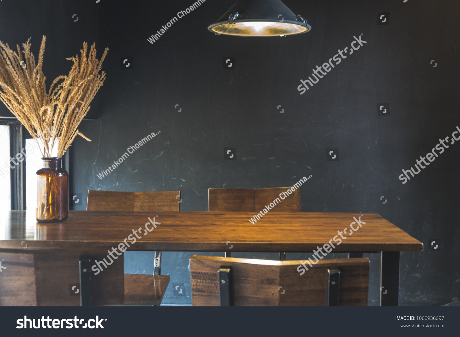 Dark dining table with wooden chair and dry flower in vintage design room #1066936697