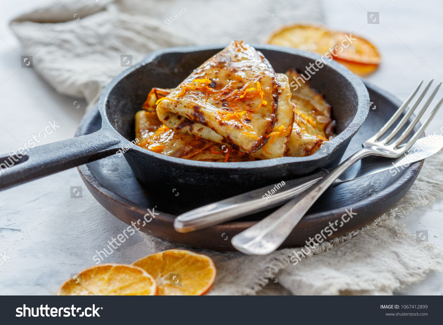 Traditional French crepe Suzette with orange sauce in a cast iron pan. #1067412899
