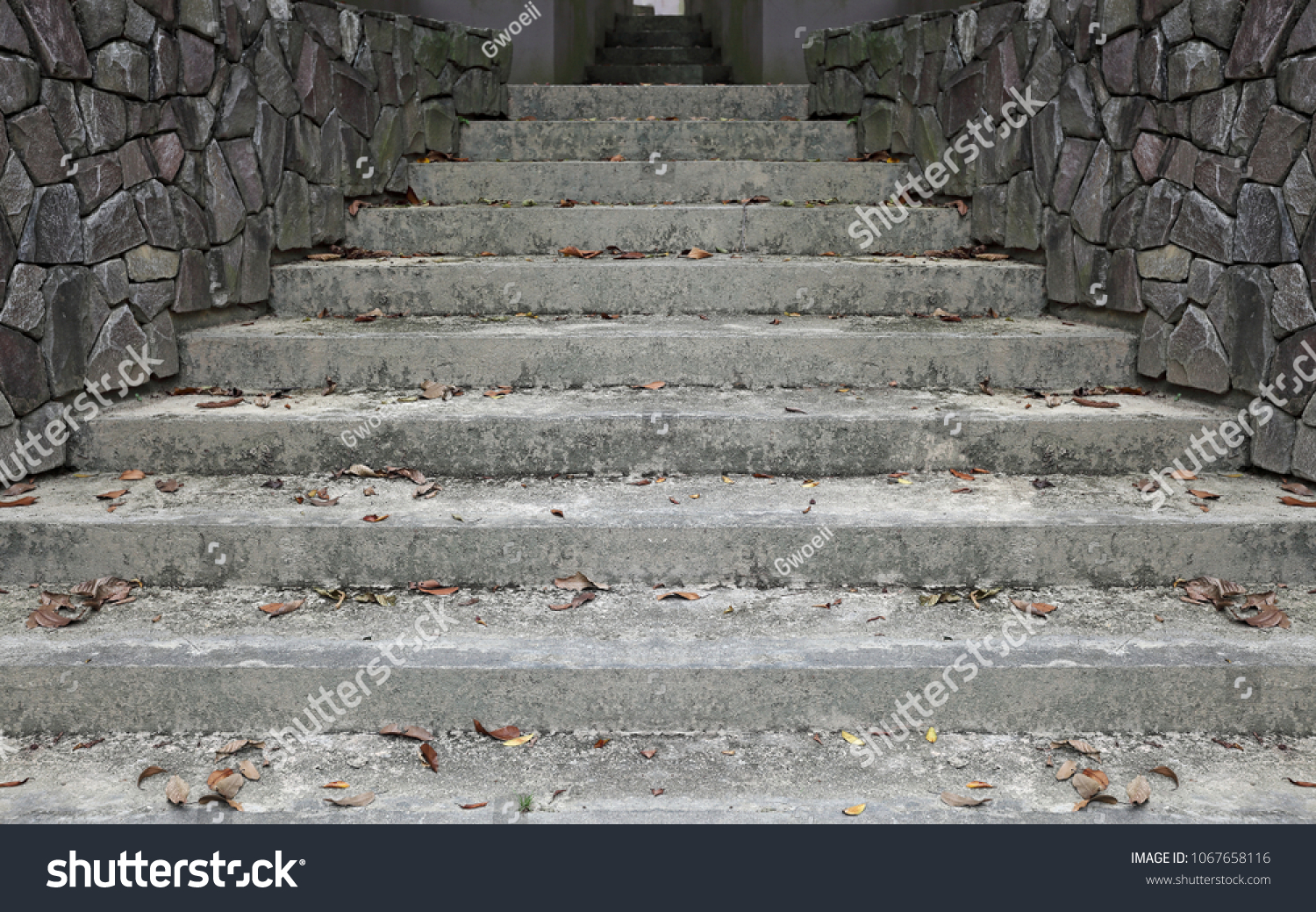 Grungy concrete staircase up a corridor.  #1067658116