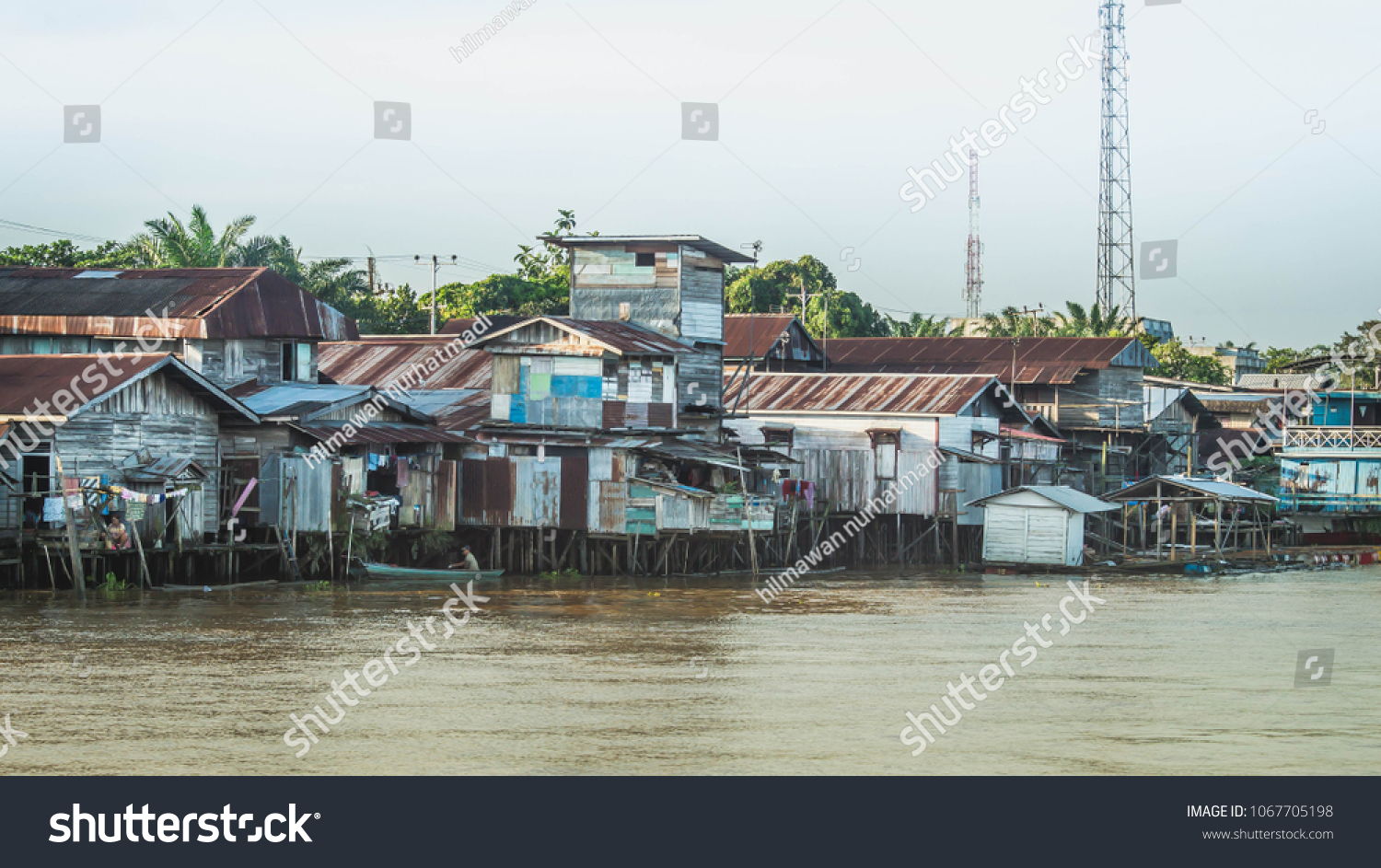 wooden house on the riverbank. slum area over the river. poverty and social problem concept #1067705198