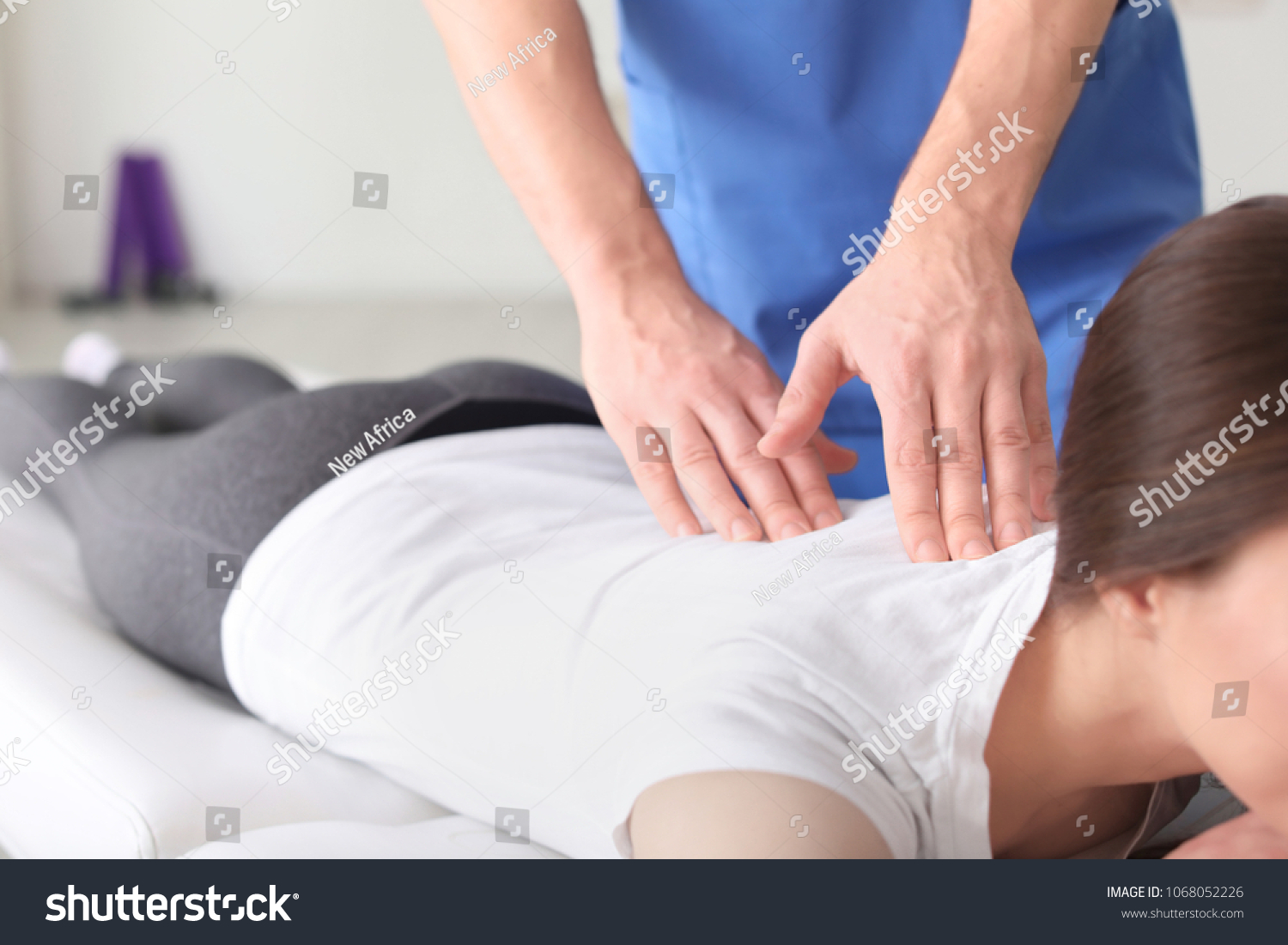 Physiotherapist working with female patient in clinic #1068052226