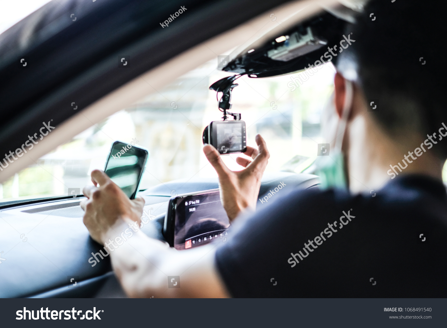 Close up Technician Hand with Car Camera and Smartphone Inside Car and Blur Man as a Foreground #1068491540