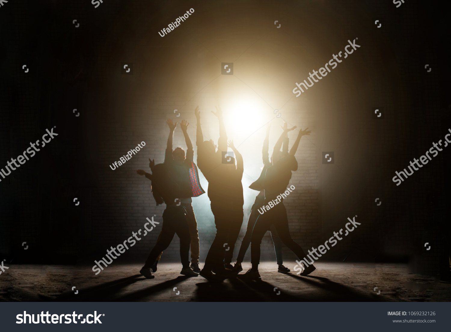 young people standing around with raised hands. praying together to the sun.influence of sect. worship light. worship the Sun. Sun cult. dancing movies #1069232126