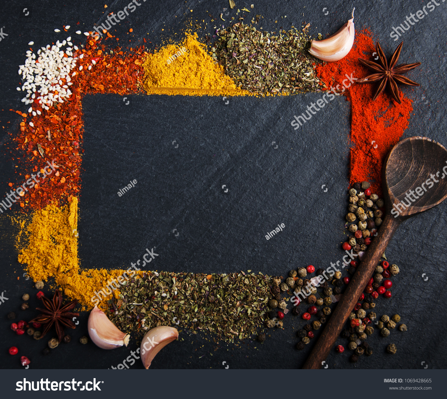 Different kind of spices on a black stone background #1069428665