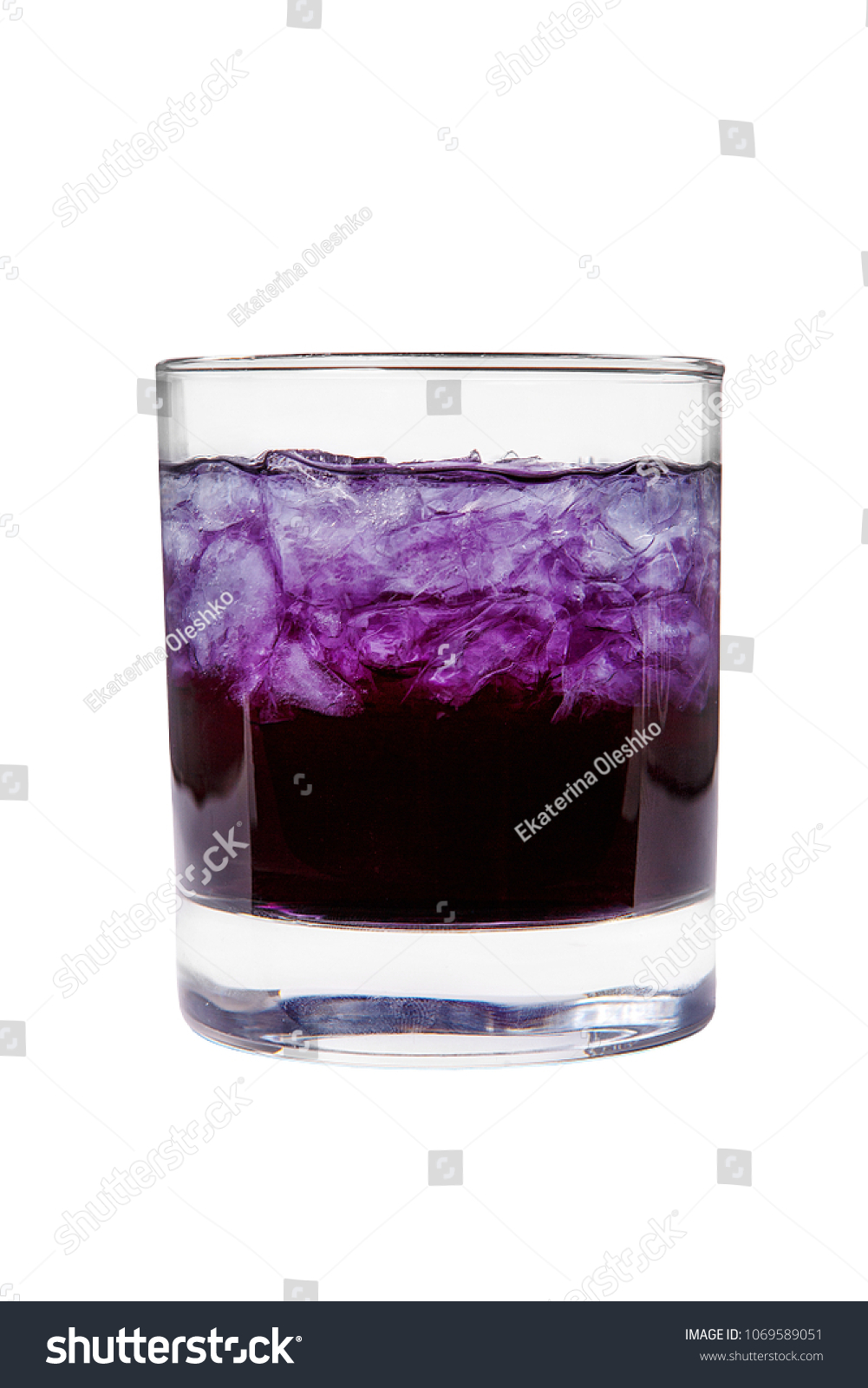 A one-color, purple clear cocktail in a low glass with crushed ice frappe. Side view. Isolated white background. Drink for the menu restaurant, bar, cafe #1069589051