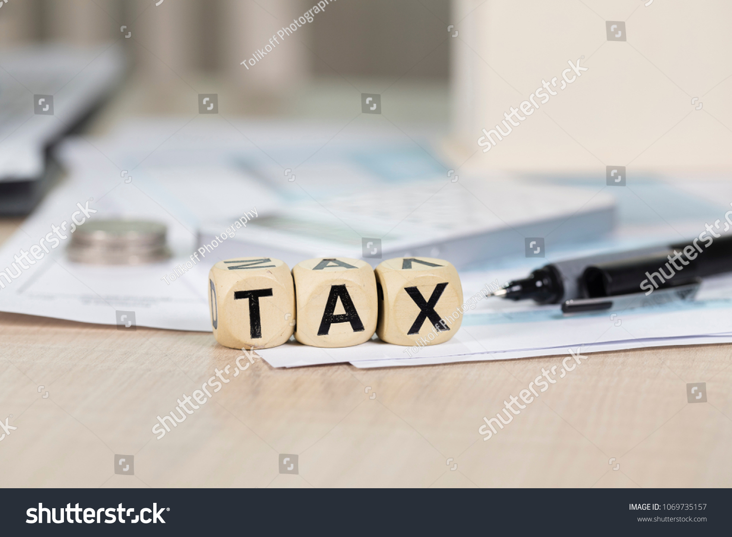 Word TAX composed of wooden letters in front of handmade house. Closeup #1069735157