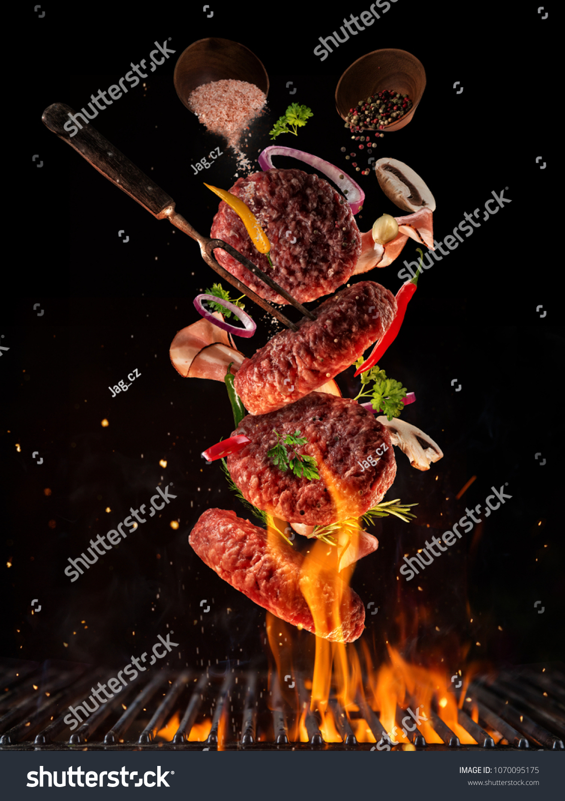 Flying pieces of beef meat pieces on hamburger from grill grid, isolated on black background. Concept of flying food, very high resolution image #1070095175