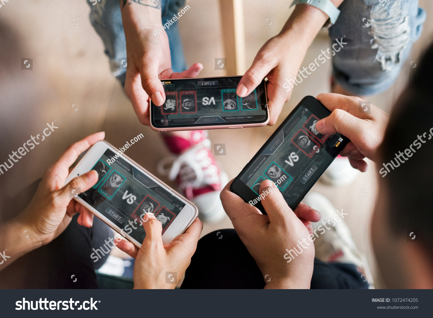 Group of diverse friends playing game on mobile phone #1072474205