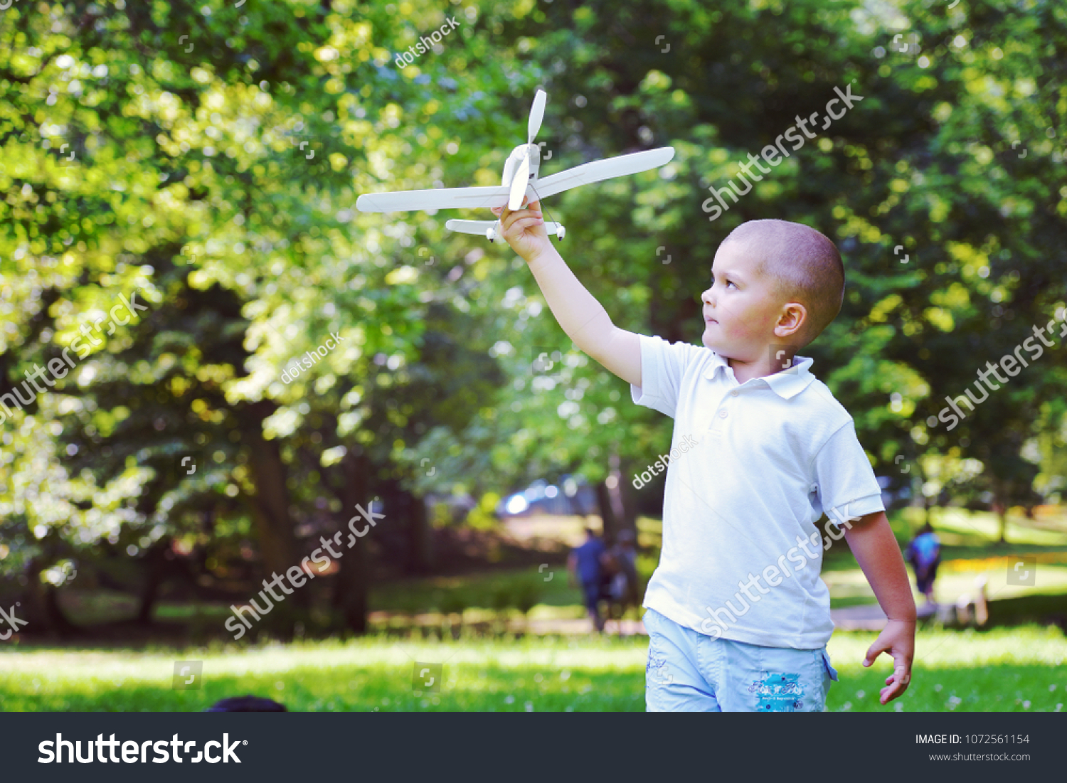 happy boy play and  throw airplane in park #1072561154