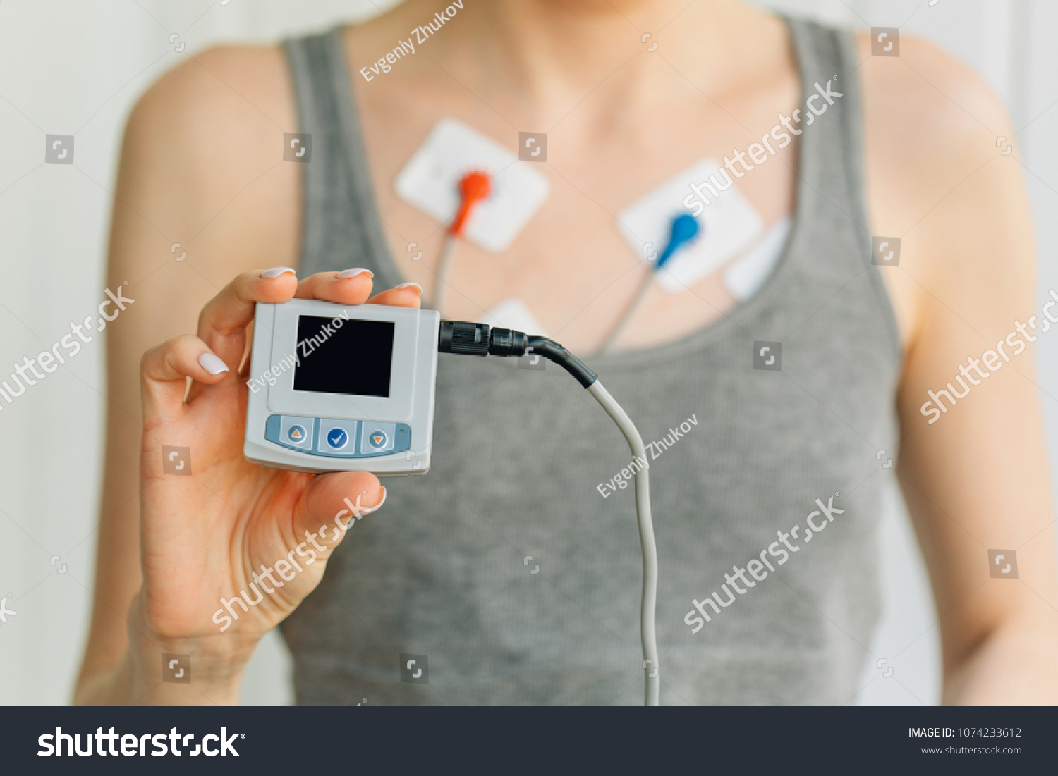 Woman wearing holter monitor device for daily monitoring of an electrocardiogram. Treatment of heart diseases #1074233612