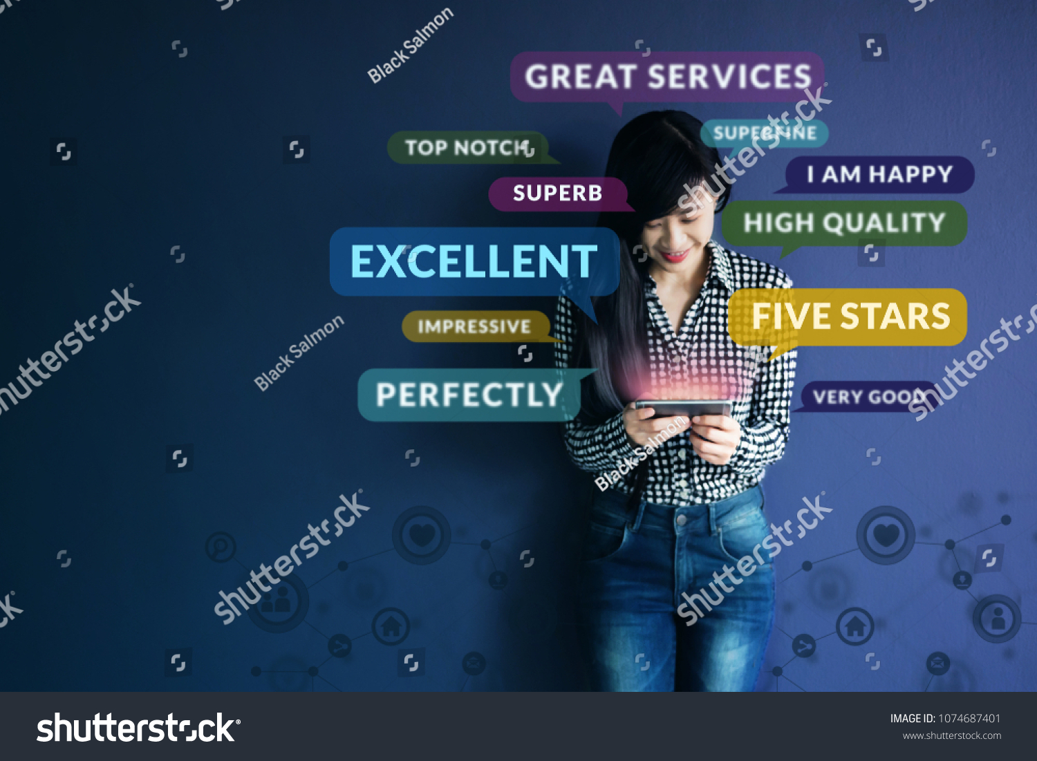 Customer Experience Concept. Soft focus of Happy Client standing at the Wall, Smiling while using Smartphone. Surrounded by Positive Review in Speech Bubble and Social Network icons #1074687401