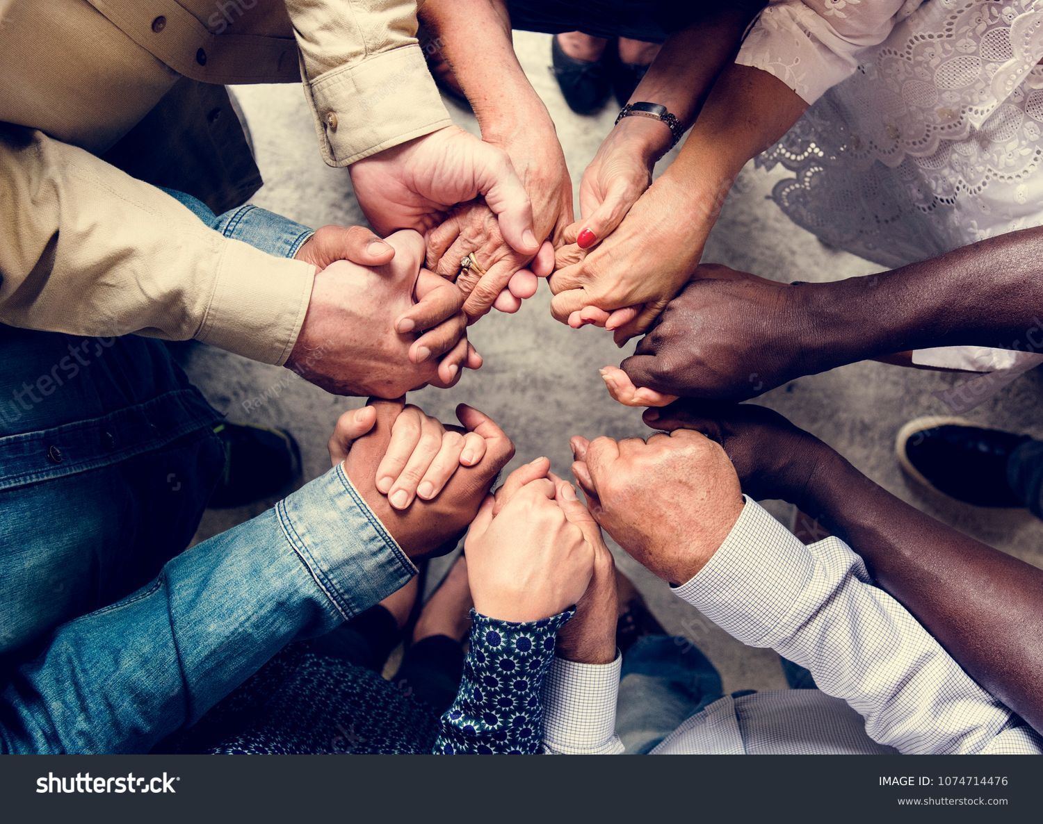 Group of diverse hands holding each other support together teamwork aerial view #1074714476
