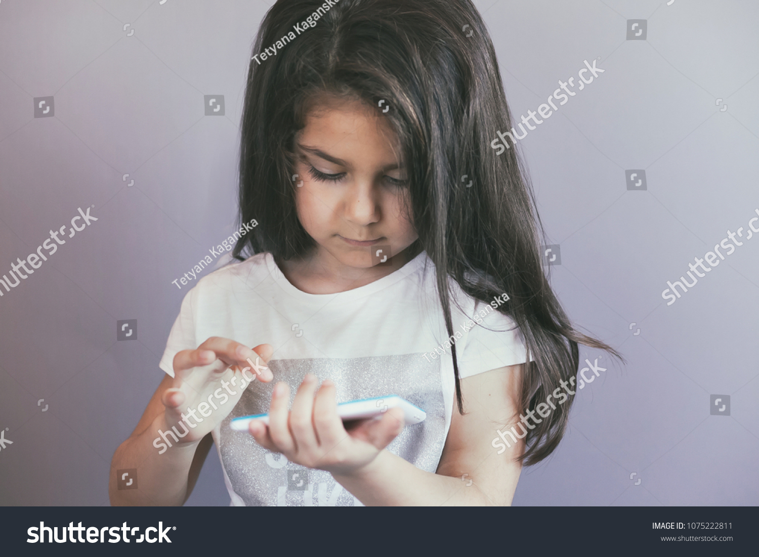 leisure, childhood, technology and people concept - cute little girl child with gadget. Toned image. #1075222811