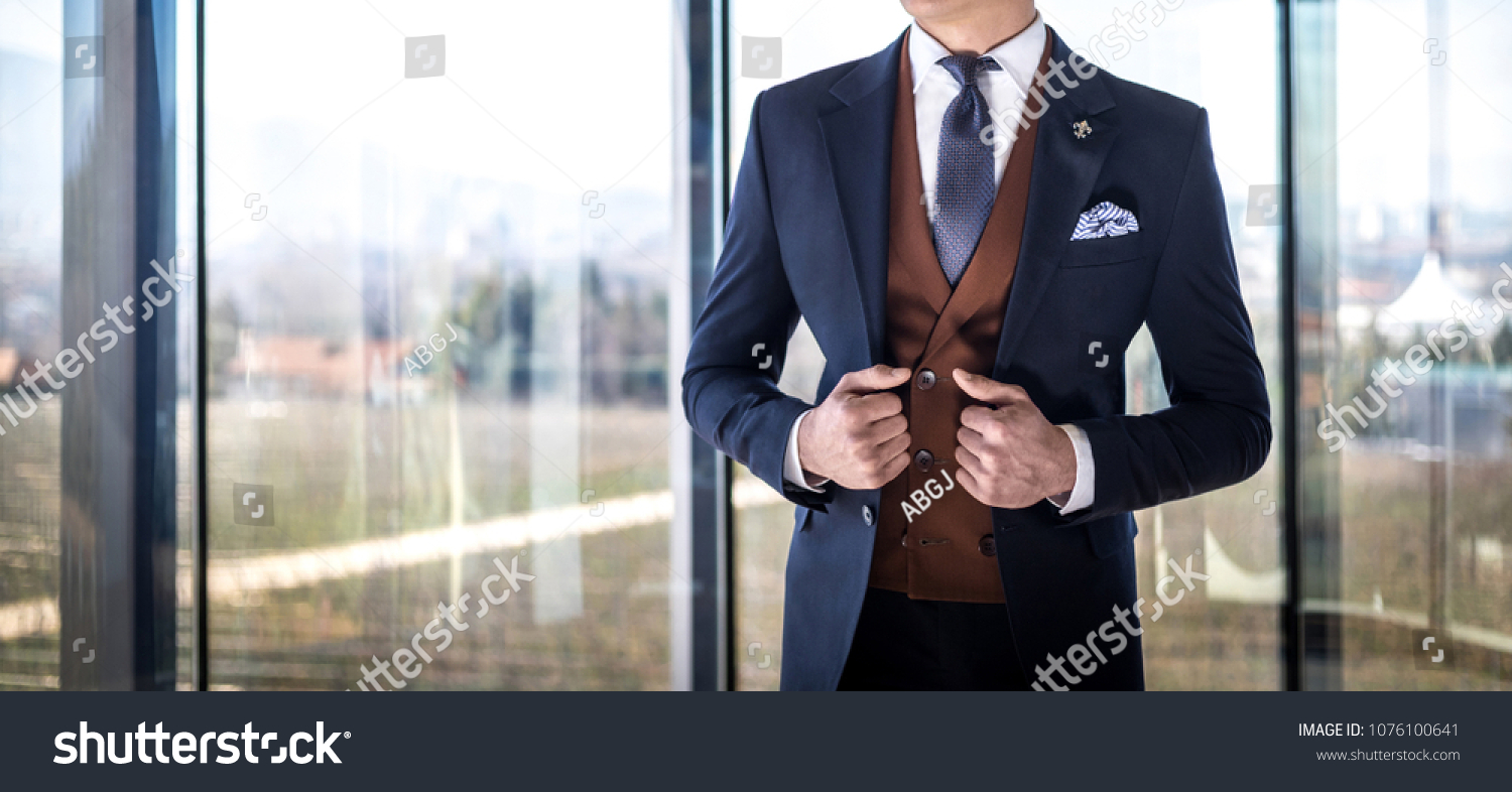 Man in custom tailored suit posing indoors #1076100641