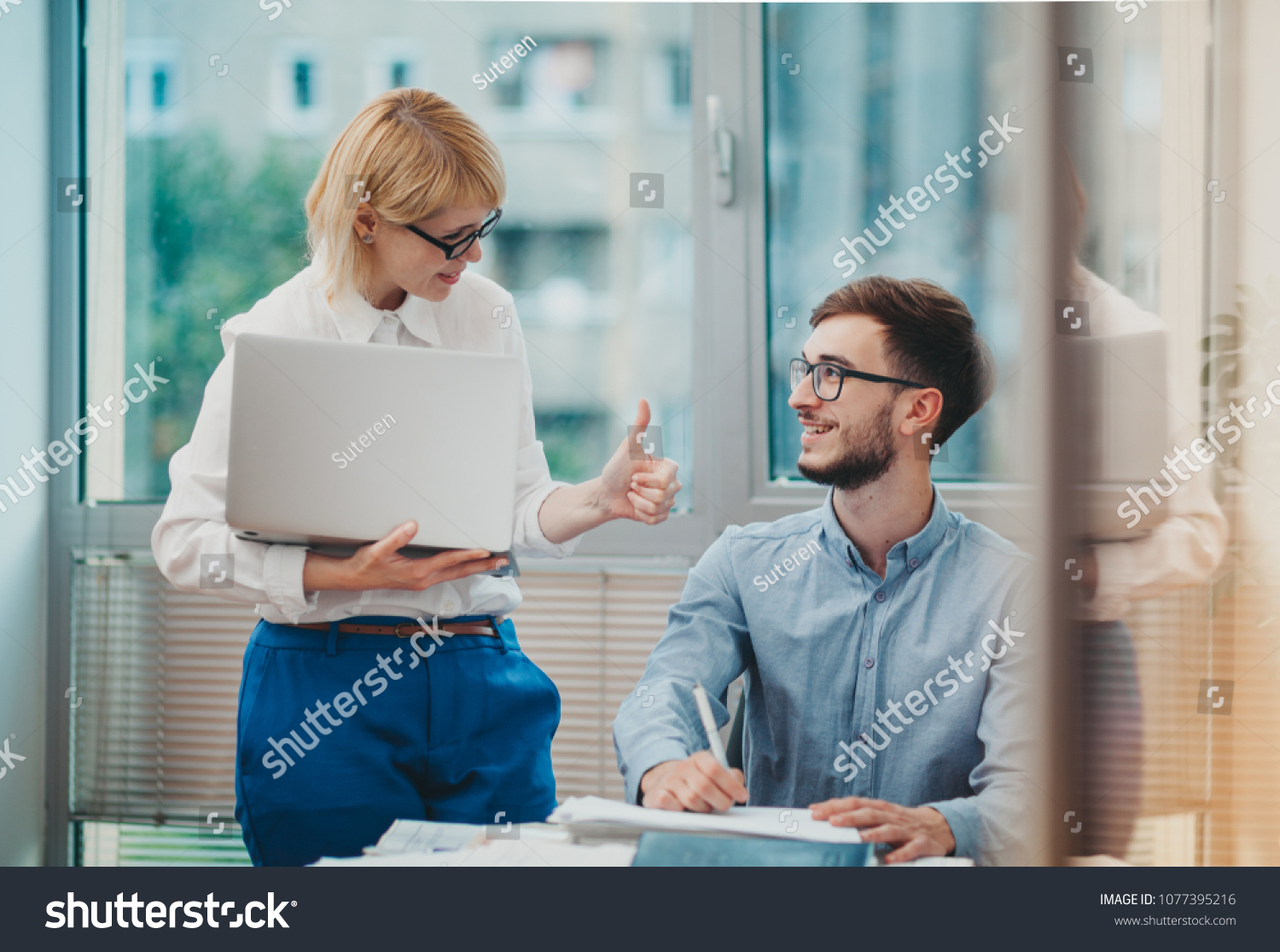 Manager giving feedback to young intern #1077395216