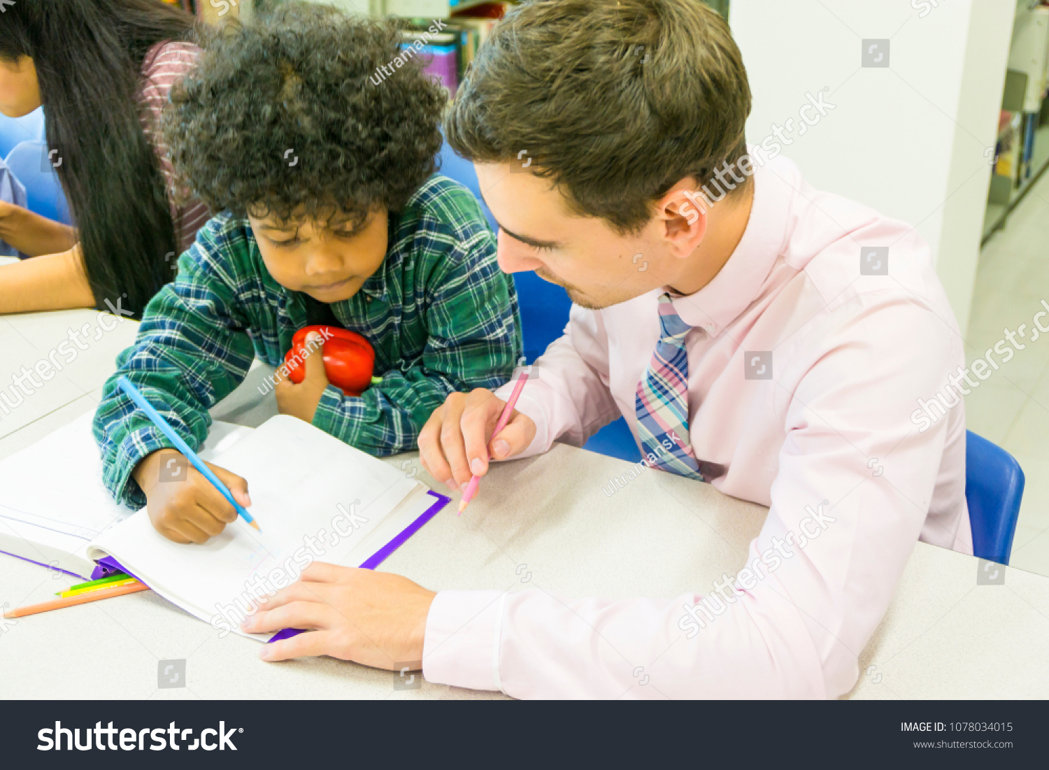 man teacher and kid student learn with book at bookshelf background #1078034015