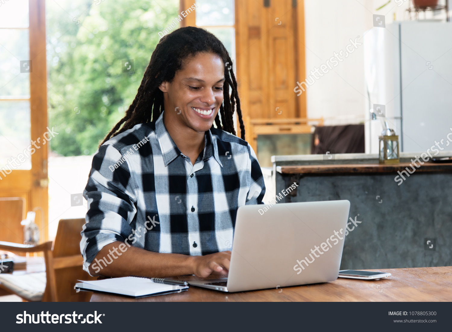 Creative latin american man with dreadlocks working at computer at home #1078805300