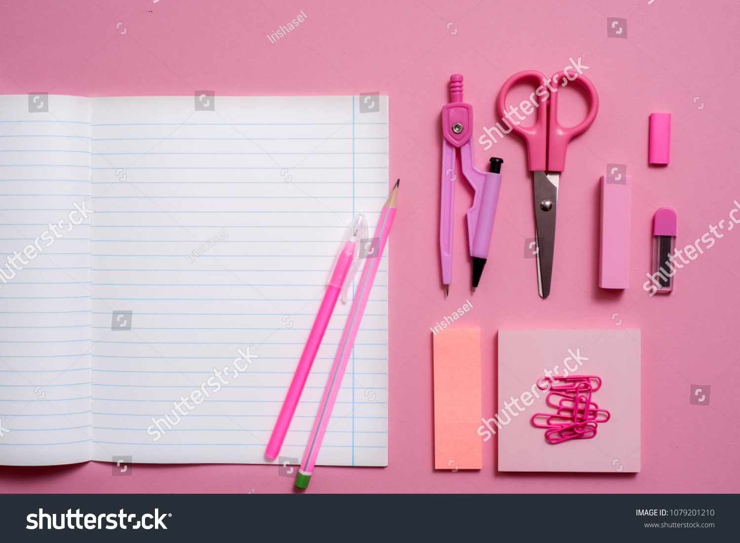 On pink background, school accessories and a pen, colored pencils, a pair of compasses, a pair of compasses, a pair of scissors. Copy space, top view #1079201210