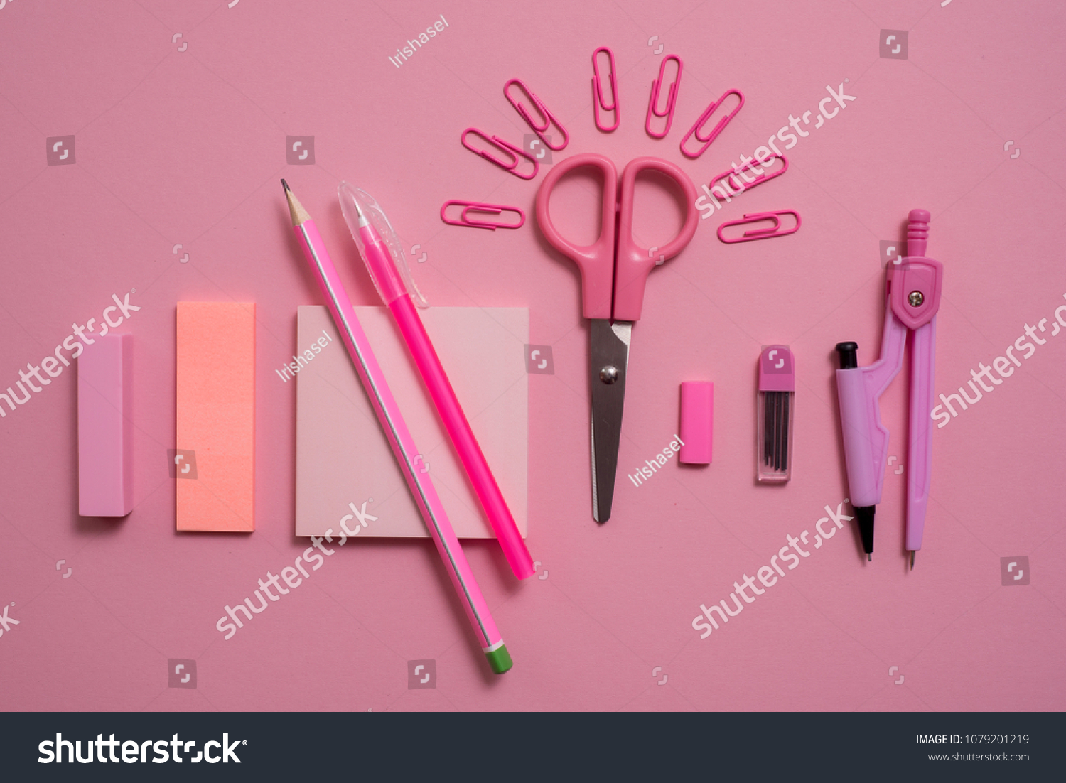 On pink background, school accessories and a pen, colored pencils, a pair of compasses, a pair of compasses, a pair of scissors. Copy space, top view #1079201219