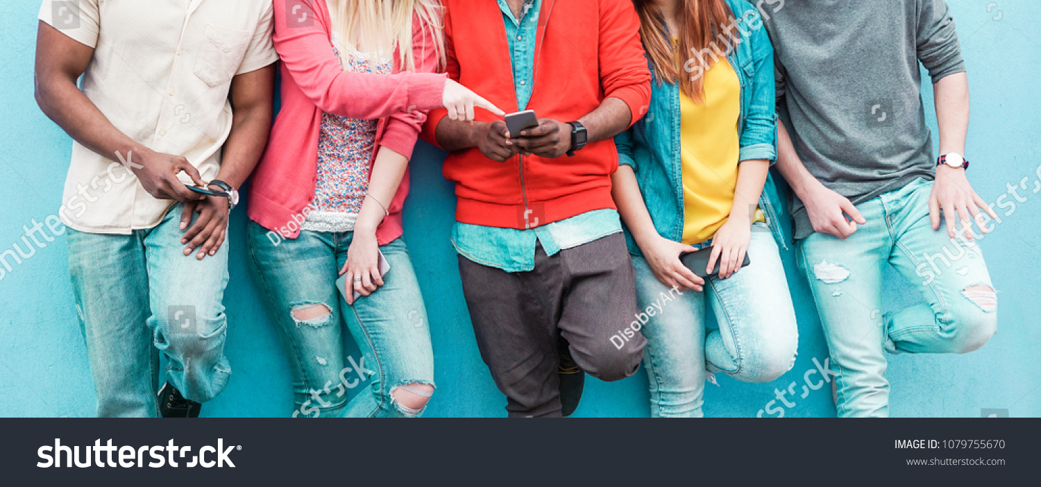 Group of friends watching smart mobile phone - Teenagers addiction to new technology trends - Youth lifestyle, tech, social, millennial generation and friendship concept - Main focus on center hands #1079755670