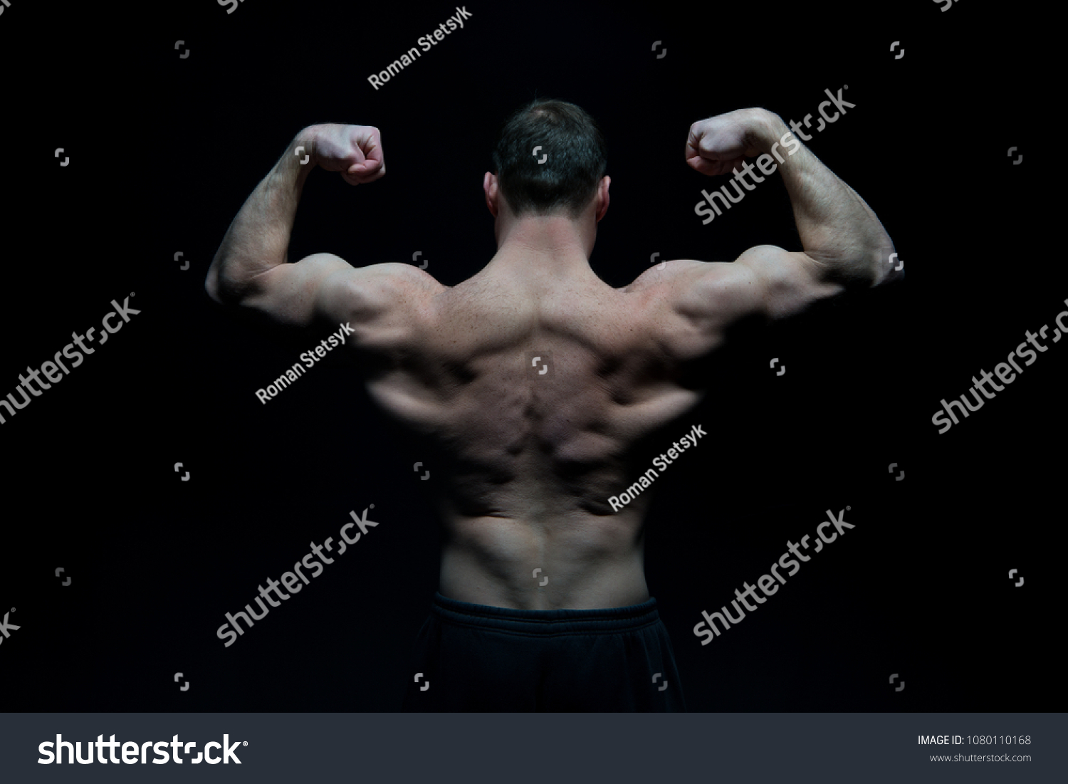 Bodybuilder with fit torso, back view. Man athlete flex arm muscles. Sportsman show biceps and triceps. Workout and training activity in gym. Sport power and bodycare concept. #1080110168