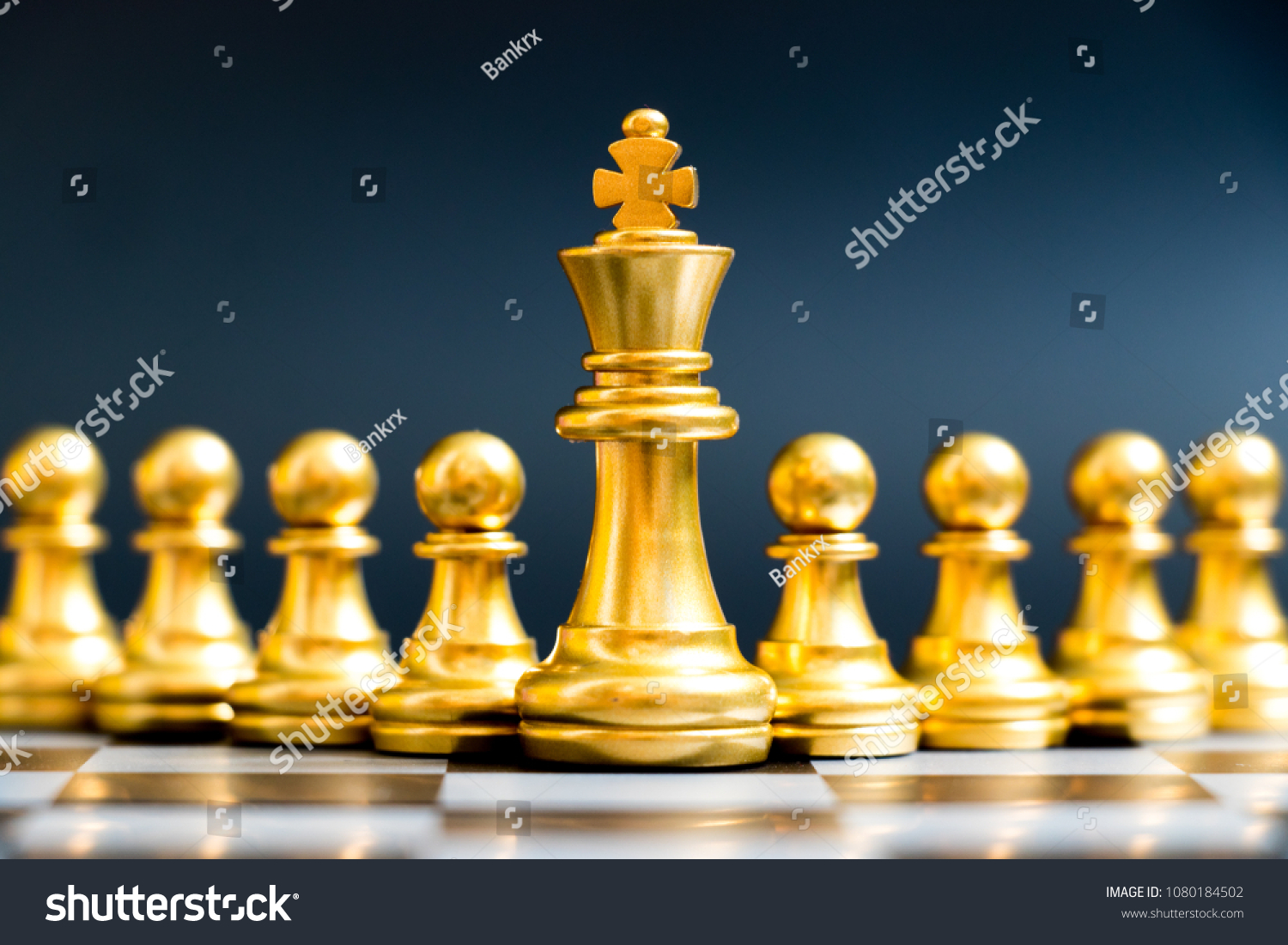 Gold king chess piece stand in front of pawn on black background (Concept of leadership, management) #1080184502