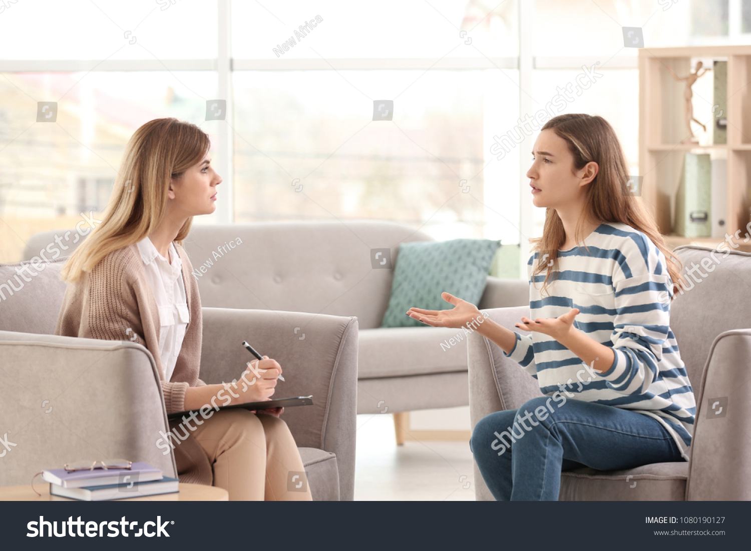 Young female psychologist working with teenage girl in office #1080190127